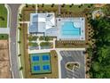 Aerial view of community clubhouse, swimming pool, tennis courts, parking, and manicured green spaces at 5385 Keepsake Court, Cumming, GA 30040