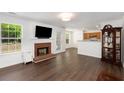 Cozy living room with brick fireplace, dark hardwood floors, and plenty of natural light at 2181 Poplar Grove Ct, Snellville, GA 30078