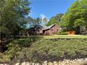 View of the red brick exterior with large front lawn and manicured shrubbery at 501 Wedgepark Dr, Mcdonough, GA 30252