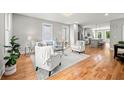 Open-concept living room with hardwood floors flowing into a kitchen, furnished with modern sofas and chairs at 106 Hogue St, Atlanta, GA 30312