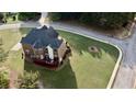 Brick home with deck and large backyard in a residential neighborhood, aerial view of house from above at 3240 Letha Woods Sw Dr, Conyers, GA 30094