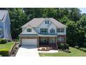 Charming two-story home with a stone and brick facade, attached garage, and landscaped front yard at 6765 Creek View Ln, Cumming, GA 30041