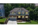 Charming two-story home featuring a blend of brick and siding, with a well-manicured lawn and inviting front porch at 6765 Creek View Ln, Cumming, GA 30041