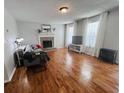 Cozy living room featuring a fireplace, hardwood floors, and neutral decor at 102 Collins Way, Douglasville, GA 30134