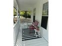 Inviting covered porch featuring a red chair, black and white rug, and stylish decor at 102 Collins Way, Douglasville, GA 30134