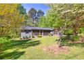 Beautiful house with green front lawn, a screened porch and lush trees at 1878 Suwanee Roberts Ct, Lawrenceville, GA 30043