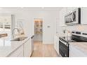 Open kitchen design boasts white cabinets, stainless appliances, granite countertops, and a pantry at 1008 Sutherland Lane (Lot 39), Lawrenceville, GA 30043
