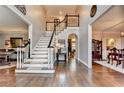 Elegant foyer features hardwood floors, a staircase with white railings and black trim, and views into adjacent rooms at 10355 Oxford Mill Cir, Johns Creek, GA 30022