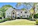 Charming two-story home with stone accents and landscaped front yard, lush green lawn at 10355 Oxford Mill Cir, Johns Creek, GA 30022