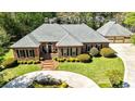 Beautiful brick home with a three car garage, manicured lawn, and a circular driveway at 8518 Shoreview Ct, Jonesboro, GA 30236
