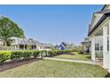 Community green space with well-manicured grass, mature trees, and charming neighborhood buildings at 89 Little Magnolia Ln, Auburn, GA 30011