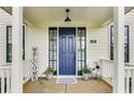 Inviting front porch with blue door, decorative plants, and a welcome sign, creating a warm entrance at 89 Little Magnolia Ln, Auburn, GA 30011