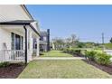 Well-maintained side yard with lush grass, manicured hedges, and a sidewalk leading to neighboring homes at 89 Little Magnolia Ln, Auburn, GA 30011