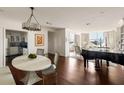 Open living space showcasing a kitchen, dining area, and a bright living area with city views and a baby grand piano at 2479 Peachtree Ne Rd # 1805, Atlanta, GA 30305