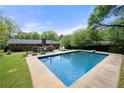 In-ground pool surrounded by a concrete patio, backyard landscaping, and seating at 690 Manor Ridge Sw Dr, Mableton, GA 30126