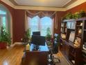 Comfortable home office with hardwood floors, built-in bookshelves, and plants at 104 Lumby Ln, Stockbridge, GA 30281