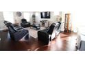 Open concept living room showcases dark wood flooring, and an array of comfortable black leather furniture at 166 Fender Walk, Marietta, GA 30060