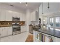 Modern kitchen with stainless steel appliances, granite countertops, and access to the living room at 3621 Vinings Slope Se # 3204, Atlanta, GA 30339