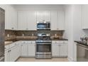 Well-equipped kitchen with stainless steel appliances, ample cabinet space, and tiled backsplash at 3621 Vinings Slope Se # 3204, Atlanta, GA 30339