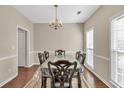 Formal dining room featuring wood floors, chandelier lighting, chair rail molding, and natural light from windows at 210 Chandler Ct, Sugar Hill, GA 30518