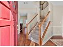Inviting foyer with hardwood floors, a staircase with white railings, and a view into the living area at 210 Chandler Ct, Sugar Hill, GA 30518