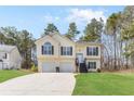 Inviting two-story home featuring a well-manicured lawn, two-car garage, and classic architectural details at 7806 Poppy Seed Pl, Winston, GA 30187