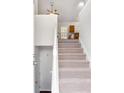 Bright entryway featuring a carpeted staircase with white banister, leading to the upper level of the home at 7806 Poppy Seed Pl, Winston, GA 30187
