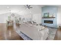 Bright living room showcasing an elegant fireplace, hardwood floors, and an open layout to the kitchen and dining area at 225 Valley Dr, Roswell, GA 30075