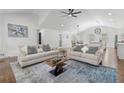 Spacious living room with hardwood floors, vaulted ceiling, and stylish furniture, connecting to the kitchen and dining at 225 Valley Dr, Roswell, GA 30075