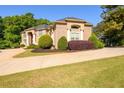 Stunning brick home featuring a well-manicured lawn, circular driveway, and vibrant landscaping elements at 50 S Underwood Dr, Covington, GA 30016