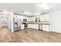 Spacious kitchen with stainless steel appliances, granite countertops, and white cabinets, complemented by wood flooring at 8405 Military Way, Douglasville, GA 30134