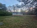 View of the home's backyard with green grass, trees, and a blue sky at , Stockbridge, GA 30281