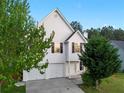 Inviting two-story home with a two-car garage, mature trees, and landscaping at 1389 Shadow Creek Ave, Hampton, GA 30228