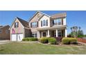Two-story brick home with a covered porch, well-maintained lawn, and attached two-car garage offers curb appeal at 209 Crestmont Way, Canton, GA 30114
