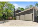 Exterior view of a three-car garage with a wide concrete driveway and well-maintained landscaping at 335 Birkdale Dr, Fayetteville, GA 30215