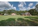 Expansive backyard featuring lush greenery, a trailer, and outbuildings, offering ample space for outdoor activities at 4345 Commodore Rd, Powder Springs, GA 30127