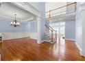 Open foyer boasts hardwood floors, staircase, and elegant chandelier creating a grand entrance at 562 Grassmeade Way, Snellville, GA 30078