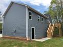 Rear view of home featuring a backyard deck, exterior door and wooded lot at 202 Gamel Rd, Dallas, GA 30157