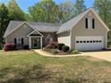 Inviting single-Gathering home featuring a well-manicured lawn and attached two-car garage at 5668 Blanchard Pl, Sugar Hill, GA 30518