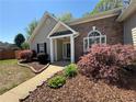 Charming home entrance with well-maintained landscaping and brick accents at 5668 Blanchard Pl, Sugar Hill, GA 30518
