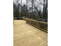 A spacious wooden deck with natural finish and wooden railings, ideal for outdoor entertainment and relaxation at 9290 Prestwick Club Dr, Johns Creek, GA 30097