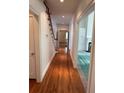 Hallway with hardwood floors leads to rooms with view of staircase at 9290 Prestwick Club Dr, Johns Creek, GA 30097