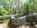 Landscaped backyard featuring stone walls, mature trees, and manicured garden beds, creating a serene outdoor space at 1490 N Crossing Circle Ne Cir # 1490, Atlanta, GA 30329