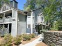 Well-maintained townhouse with a covered front porch, stone exterior wall, landscaped yard, and ample natural light at 1490 N Crossing Circle Ne Cir # 1490, Atlanta, GA 30329