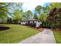 Well-manicured lawn and driveway leading to a white home with a dark-stained front porch at 2724 Parkwood Se Rd, Smyrna, GA 30080