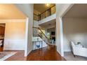Bright foyer with hardwood floors, staircase with iron railing, and a view into the living spaces at 3880 Deer Run Dr, Cumming, GA 30028