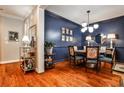 Elegant dining room featuring dark blue accent wall, modern lighting, and hardwood floors at 2250 W Village Junction Se Way, Smyrna, GA 30080