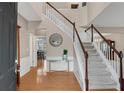 Bright foyer featuring hardwood floors, a staircase with white railings, and views into other rooms at 3925 Tugaloo River Dr, Duluth, GA 30097