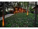 Modern brick home with landscape lighting nestled among mature trees and foliage at 151 Rockmart Dr Sw, Atlanta, GA 30314