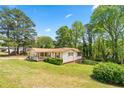 Quaint one-story home with a welcoming front porch and an expansive, tree-filled backyard at 645 Camp Perrin Rd, Lawrenceville, GA 30043